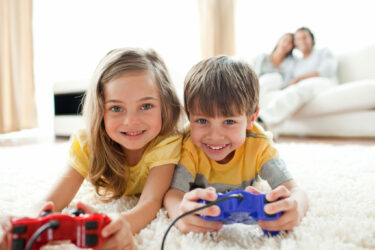 Loving siblings playing video game in the living room